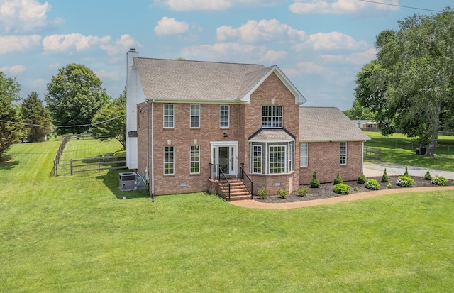 view of front facade with central AC unit and a front lawn