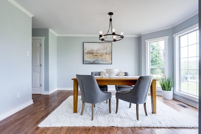 dining room with crown molding, dark hardwood / wood-style flooring, and a notable chandelier