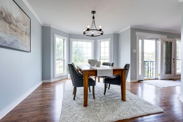 dining area with dark hardwood / wood-style flooring, crown molding, and an inviting chandelier