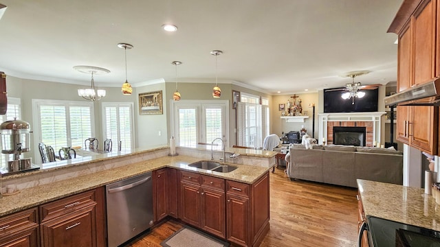 kitchen featuring sink, stainless steel dishwasher, crown molding, pendant lighting, and a fireplace