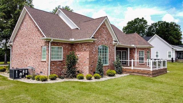 exterior space featuring a deck, a yard, and central AC