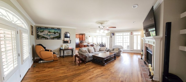 living room featuring ceiling fan, wood-type flooring, and ornamental molding