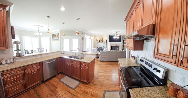 kitchen with dishwasher, stove, sink, decorative light fixtures, and light stone counters