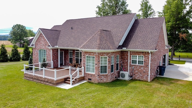 rear view of property with a yard, ac unit, and a garage