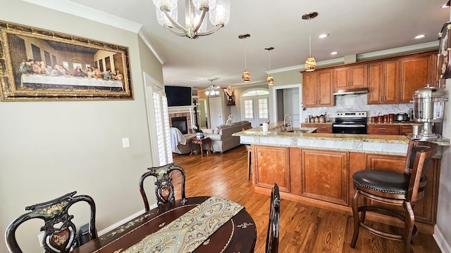 kitchen featuring decorative backsplash, electric range, a chandelier, and decorative light fixtures