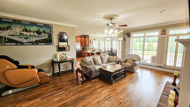 living room featuring hardwood / wood-style flooring, ceiling fan, and ornamental molding