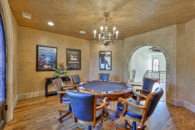 dining area with light hardwood / wood-style floors and a chandelier