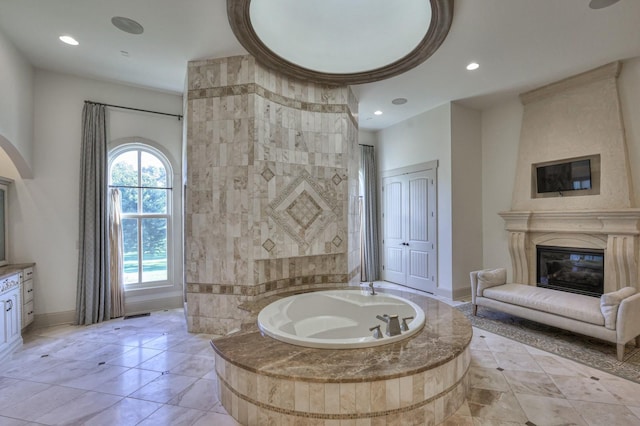 full bath featuring recessed lighting, a garden tub, a fireplace, and baseboards