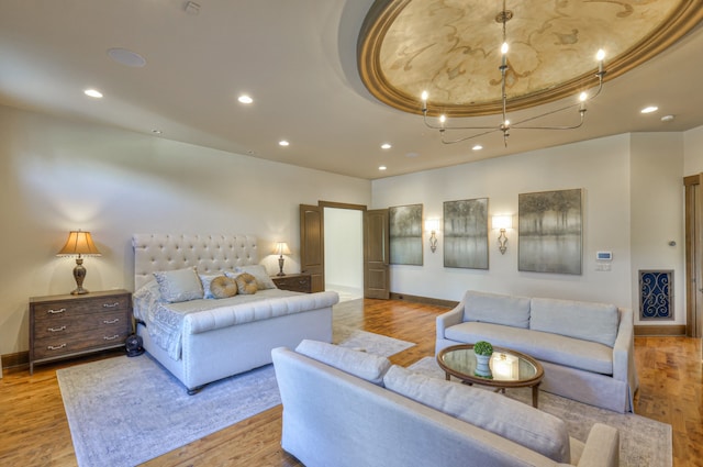 bedroom with light hardwood / wood-style flooring and a raised ceiling