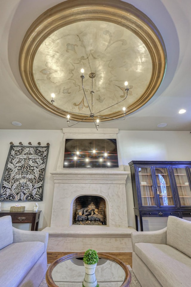 living room featuring a fireplace, a tray ceiling, and wood finished floors