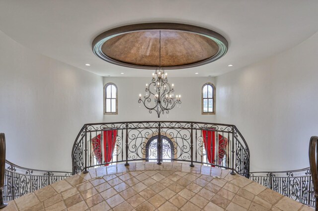 details with an inviting chandelier and a raised ceiling