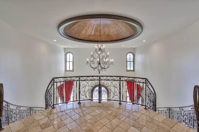 staircase with a healthy amount of sunlight, a chandelier, and recessed lighting