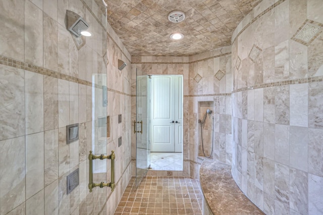 bathroom featuring tile walls and a shower stall