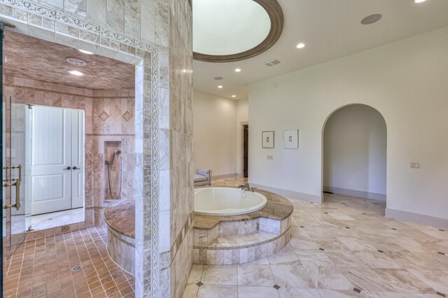 bathroom with a bath to relax in and tile flooring