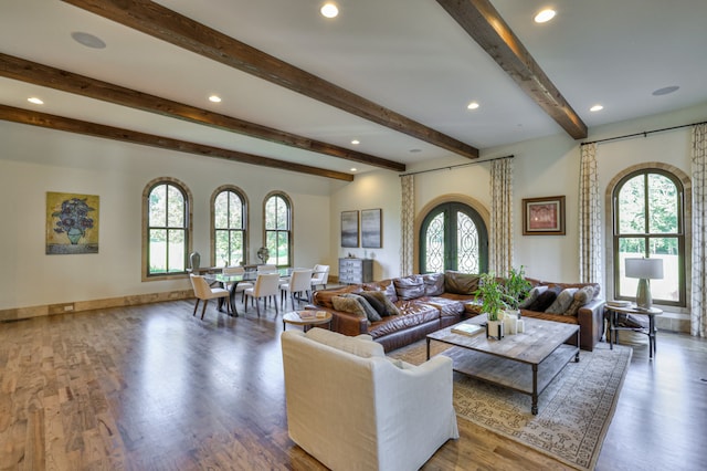 living room with a wealth of natural light, beamed ceiling, and hardwood / wood-style flooring