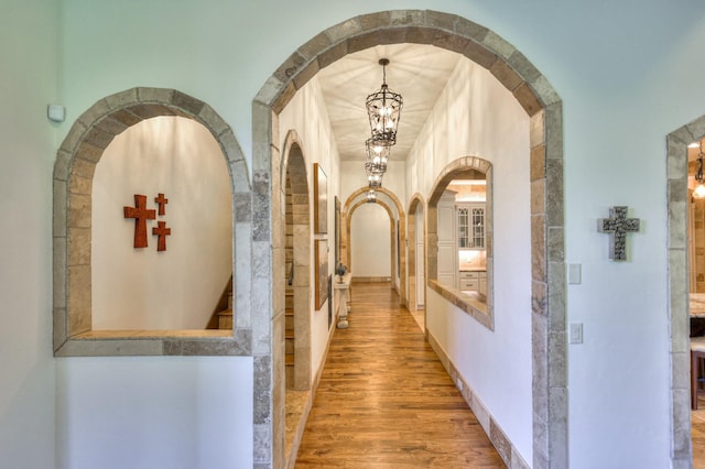 hall with light wood-style floors and baseboards