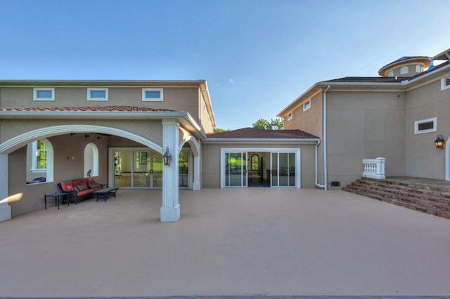 rear view of property featuring a patio and stucco siding