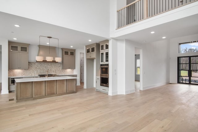 6051 Lookaway Cir, Franklin, TN 37067 - kitchen with open floor plan, stainless steel double oven, exhaust hood, backsplash, and light wood-style floors