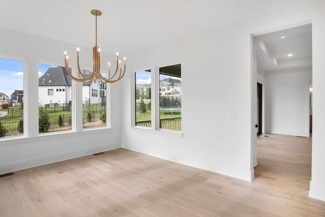 unfurnished dining area featuring a notable chandelier, recessed lighting, visible vents, baseboards, and light wood-style floors