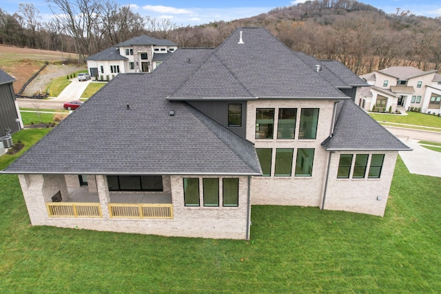 6051 Lookaway Cir, Franklin, TN 37067 - rear view of house featuring roof with shingles, a lawn, and brick siding