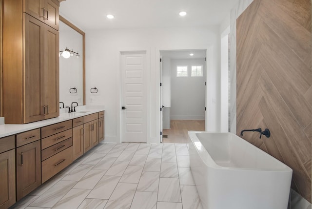 bathroom featuring vanity and a washtub