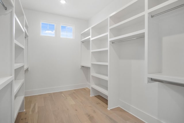 walk in closet with light hardwood / wood-style flooring