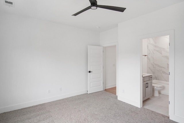 unfurnished bedroom featuring connected bathroom, light carpet, and ceiling fan