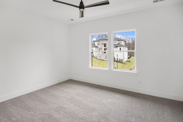 carpeted empty room with a ceiling fan, visible vents, and baseboards