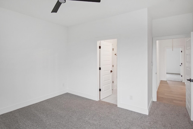 unfurnished bedroom featuring light carpet, ceiling fan, and baseboards