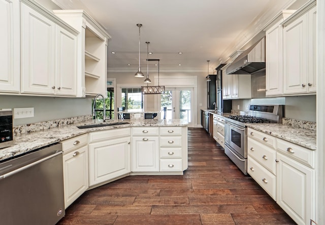 kitchen featuring kitchen peninsula, appliances with stainless steel finishes, sink, white cabinets, and hanging light fixtures