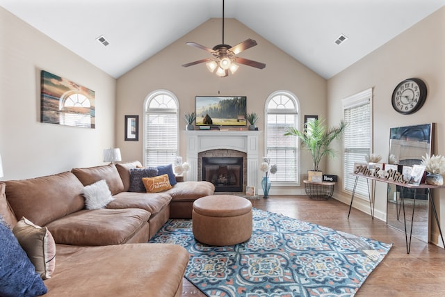 living room with hardwood / wood-style flooring, high vaulted ceiling, and ceiling fan