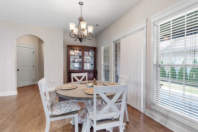 dining room with hardwood / wood-style floors and a chandelier