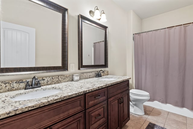 bathroom with double vanity, tile patterned floors, and toilet