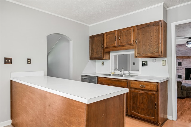 kitchen with light hardwood / wood-style floors, a textured ceiling, brick wall, sink, and dishwasher