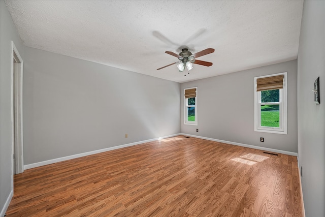 unfurnished room with ceiling fan, a textured ceiling, and wood-type flooring