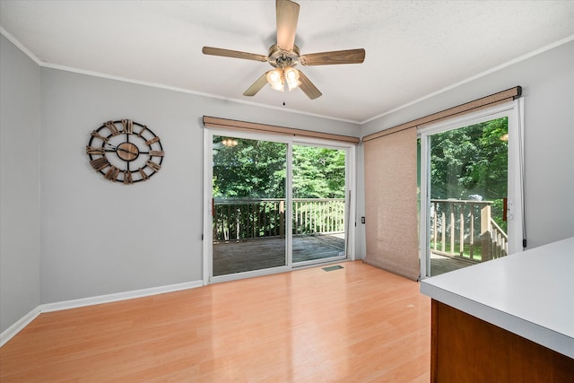 unfurnished dining area featuring light hardwood / wood-style floors, ornamental molding, and ceiling fan