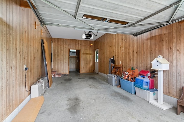 garage with a garage door opener and wood walls