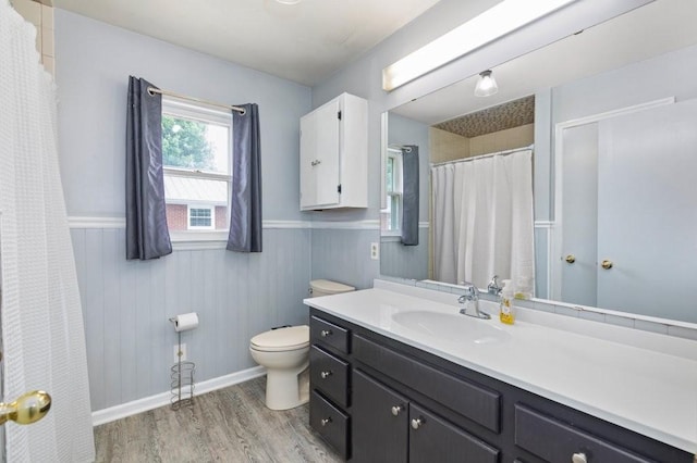 bathroom with vanity, toilet, hardwood / wood-style floors, and wood walls