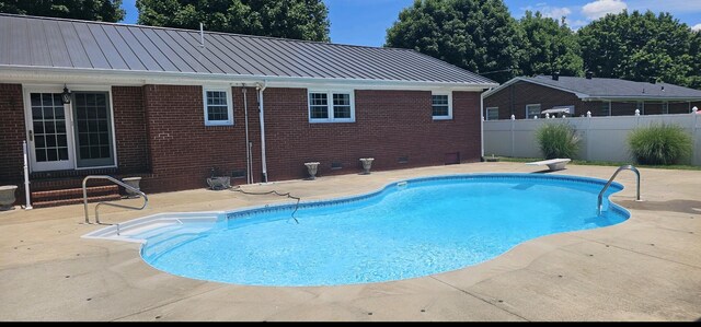 view of pool featuring a patio and a diving board