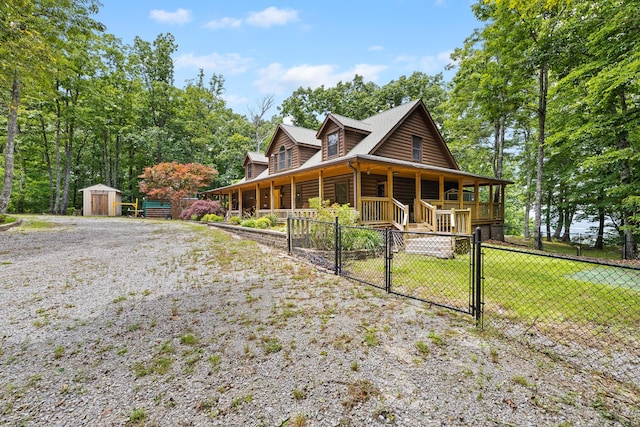 view of front of property featuring a porch, a storage shed, and a front yard