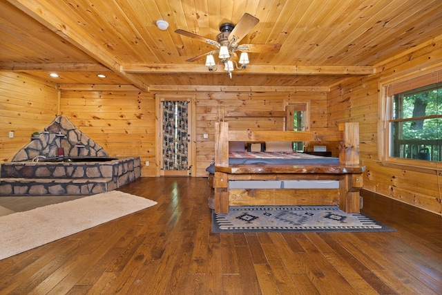 bedroom with wood walls, dark hardwood / wood-style floors, wooden ceiling, and beam ceiling