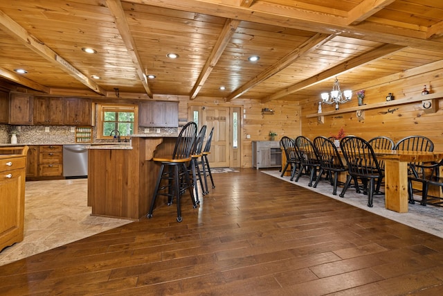 kitchen with hardwood / wood-style floors, a center island, wood ceiling, light stone counters, and stainless steel dishwasher