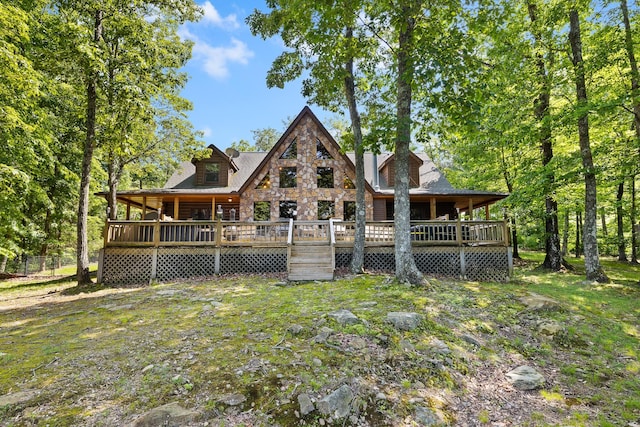 back of property with a wooden deck and a yard