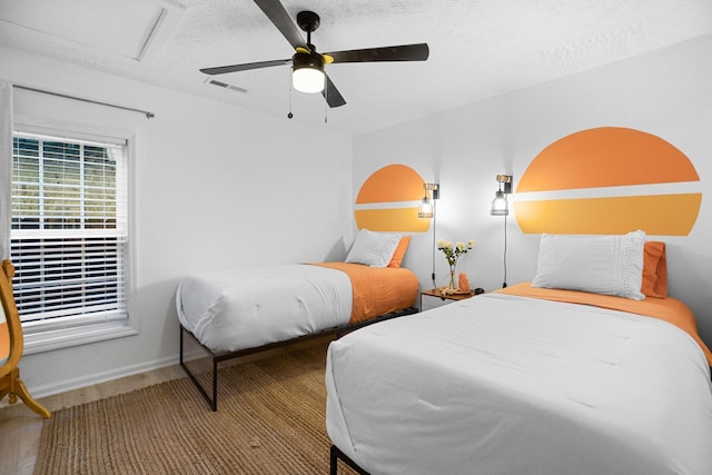 bedroom featuring hardwood / wood-style floors, ceiling fan, and a textured ceiling