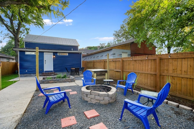 view of patio with an outdoor structure and a fire pit