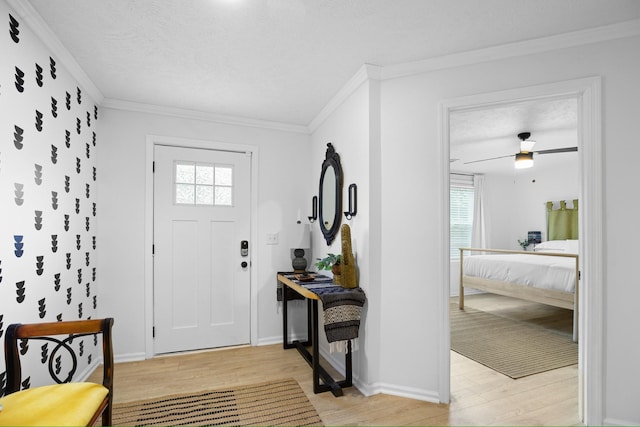 foyer with a textured ceiling, light hardwood / wood-style floors, ceiling fan, and crown molding