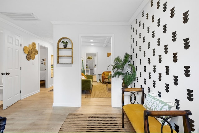 corridor with light hardwood / wood-style floors and ornamental molding