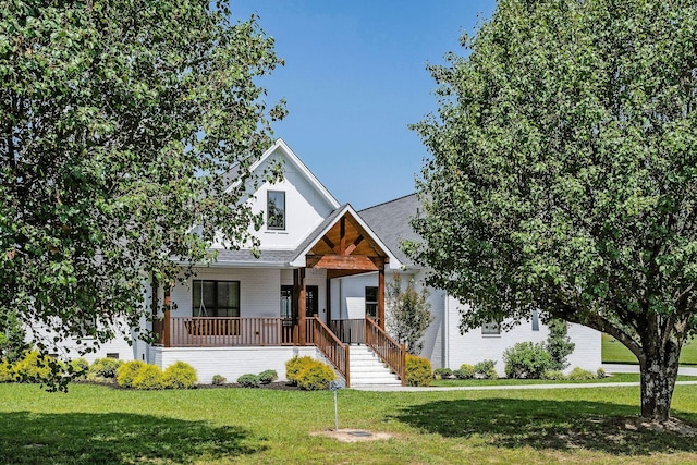 view of front of home with covered porch and a front lawn