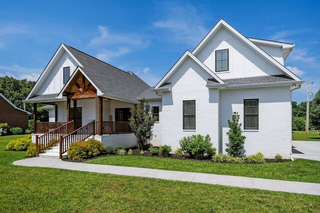 view of front of home featuring covered porch and a front lawn