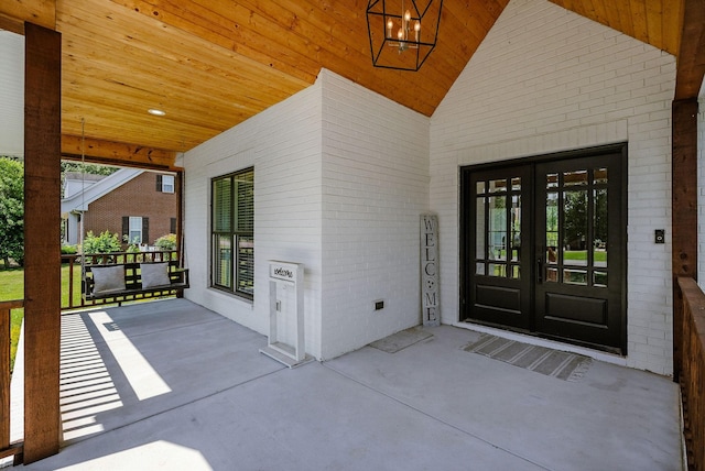 doorway to property featuring covered porch and french doors